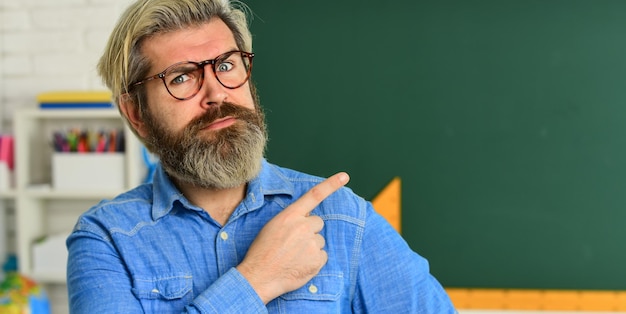 Foto wetenschap in de moderne school wiskunde is favoriete vakstudie algebra op de universiteit formele wetenschappen volwassen leraar in glazen wijzende vinger terug naar school man engineering graphics en projecten