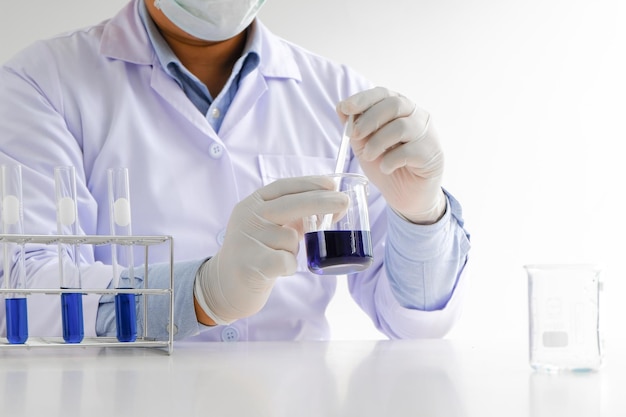 Wetenschap innovatief Mannelijke medische of wetenschappelijke laboratoriumonderzoeker voert tests uit met blauwe vloeistof in laboratoriumapparatuur wetenschappelijke experimenten technologie Coronavirus Covid19 vaccinonderzoek