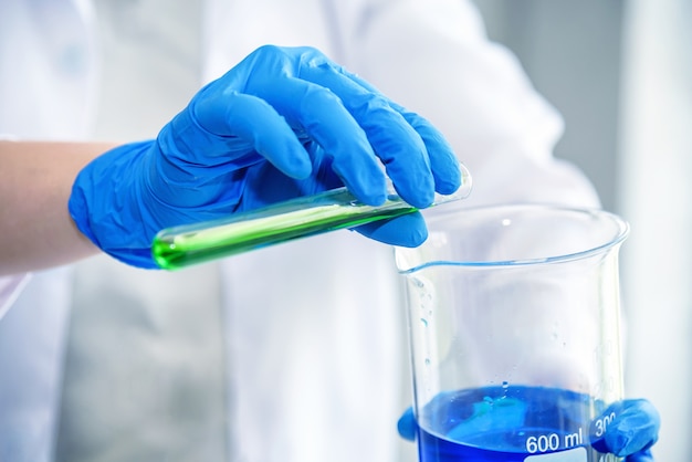 wetenschap laboratoriumonderzoeker voert test uit met blauwe en groene oplossing