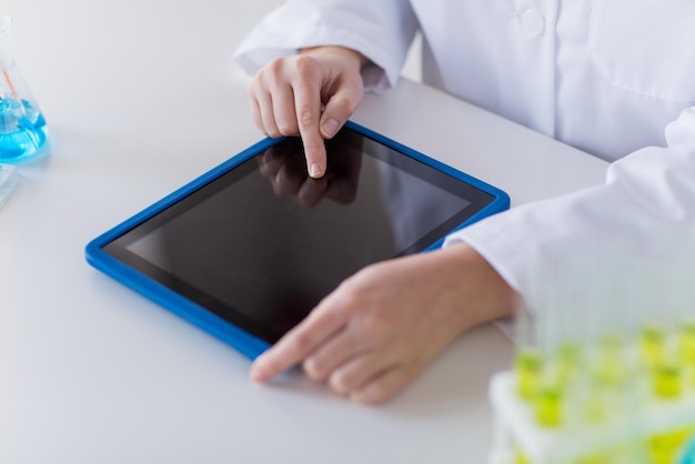 wetenschap, scheikunde, biologie, geneeskunde en mensen concept - close-up van jonge vrouwelijke wetenschapper met tablet pc computer maken van test of onderzoek in klinisch laboratorium