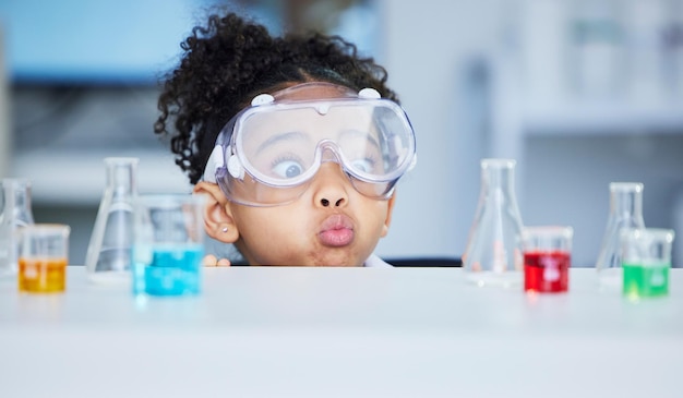 Wetenschappelijk leren en verrassen met kind in laboratorium voor experimentonderwijs en onderzoek Toekomstig grappig en kennis met gezicht van jong meisje en chemicaliën voor resultatengeneeskunde en analyse