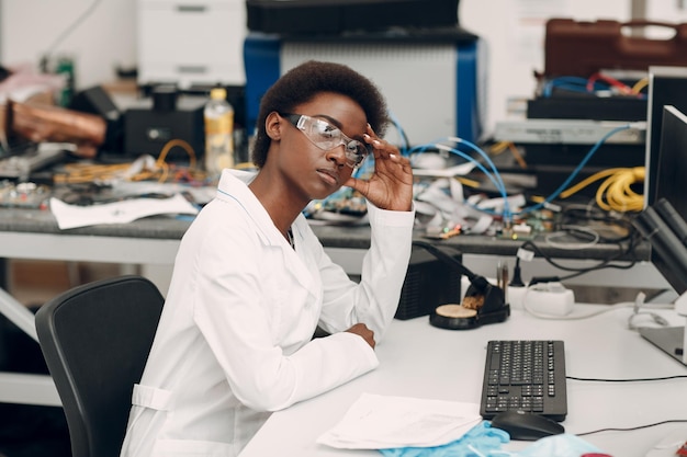 Wetenschapper Afro-Amerikaanse vrouw die in laboratorium werkt met elektronische instrumenten