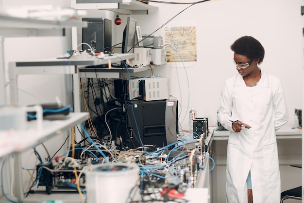 Wetenschapper afro-amerikaanse vrouw die in laboratorium werkt met elektronische instrumenten