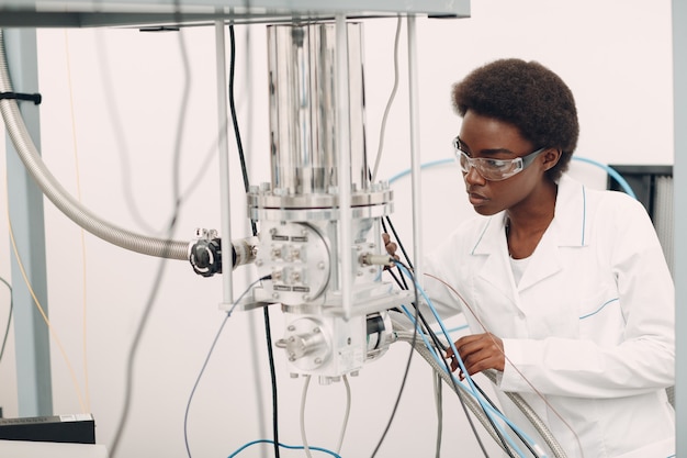 Wetenschapper afro-amerikaanse vrouw die in laboratorium werkt met elektronische tech enkele foton detector onderzoek en ontwikkeling van elektronische apparaten door kleur zwarte vrouw