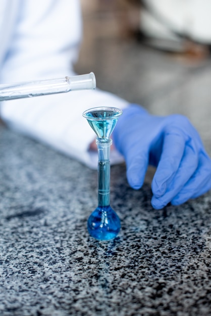 Wetenschapper blauwe oplossingen voorbereiden op het wetenschappelijk onderzoek in het laboratorium
