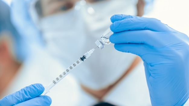 wetenschapper die een spuit vult met een nieuw vaccin