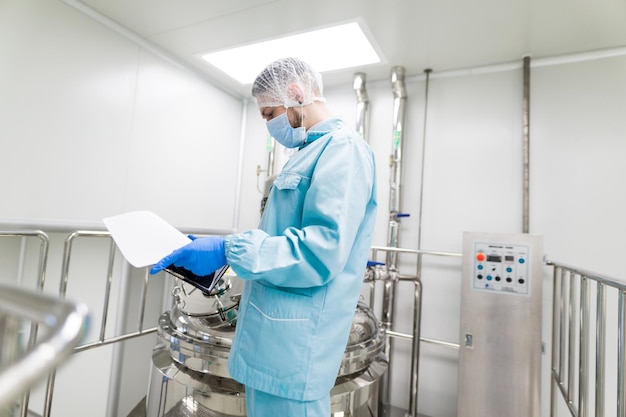 Wetenschapper in cleanroom kijken naar tablet