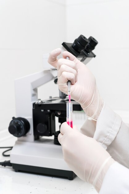 Wetenschapper vullen reageerbuis met pipet in laboratorium