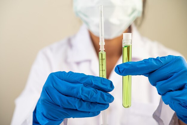 Wetenschappers dragen maskers en handschoenen en dragen bekers met vaccins
