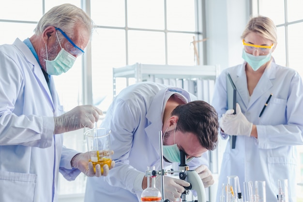 Wetenschapsleraar en studententeam die met chemische producten in laboratorium werken