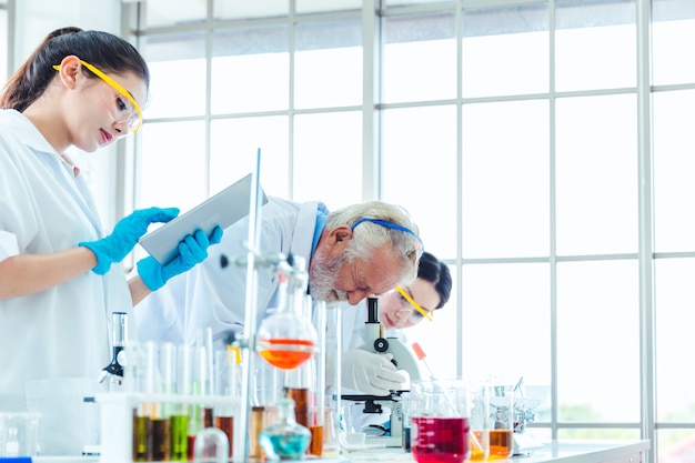 Wetenschapsleraar en studententeam die met chemische producten in laboratorium werken