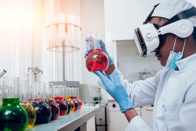 Wetenschapstechnicus in virtual reality-bril onderzoekt het medicijn in laboratorium.