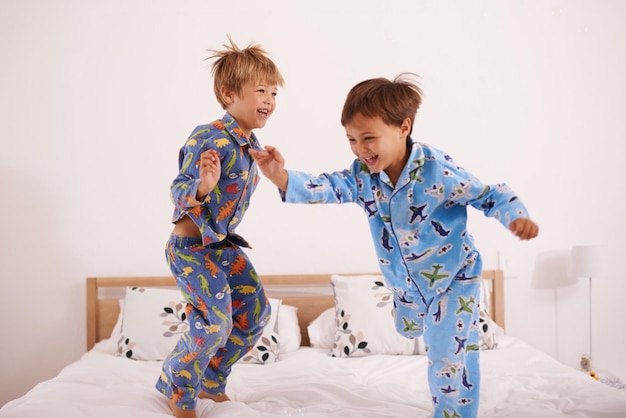 Weve got the moves likes jagger Shot of two little boys jumping on the bed