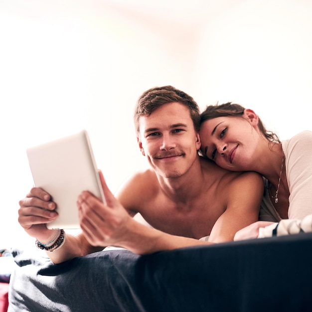 У нас сильная связь Портрет молодой пары, лениво проводящей день в постели со своим планшетом