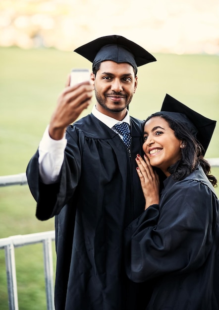 What a beautiful and glorious day its been Shot of two students taking a selfie together on graduation day