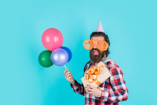 What to buy event manager with gift box brutal male on party funny man in birthday hat happy holiday celebration party goer going crazy having fun with balloons prepare for anniversary