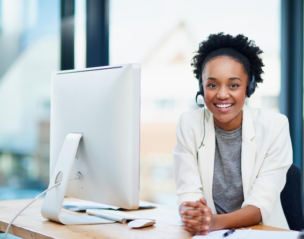 What can I do for you Cropped portrait of a young businesswoman wearing a headset while sitting in her office