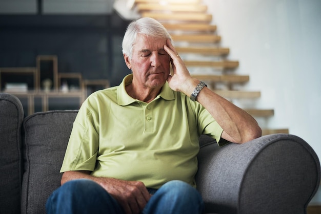 Photo what could be causing these headaches shot of a senior man suffering from a headache at home