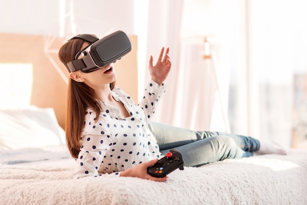 What happens. Sweet gorgeous emotional woman relaxing while playing Vr game and carrying controller