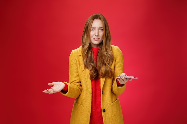 What a heck going on portrait of annoyed and confused perplexed ginger businesswoman in yellow coat ...