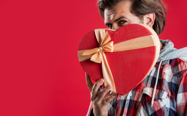 What is that boxing day discount handsome man with gift romantic date guy with beard hold heart shape box brutal mature hipster holding love present box successful shopping time copy space