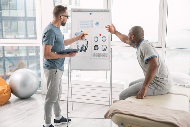 What is this. Nice good looking man pointing at the white board while asking about diagnosis