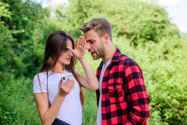 What she is hiding. personal space concept. Got lost. man pry phone of girl in park. Jealousy. couple use smartphone outdoor. navigator search. romantic date online. couple in love. Blogging concept.