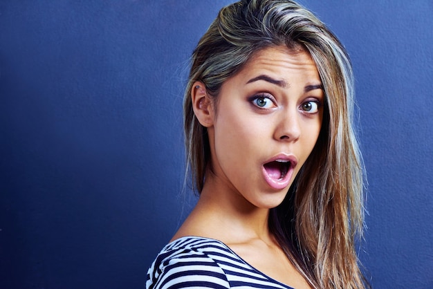 What a shocker Portrait of a shocked young woman isolated on blue