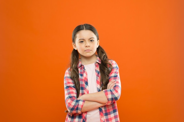 What should I do childrens day childhood memory little girl orange background kid fashion serious school girl worker uniform kid long hair small girl checkered shirt sad child