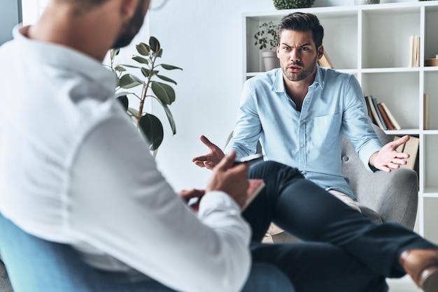 What should I do? Young frustrated man speaking and gesturing 