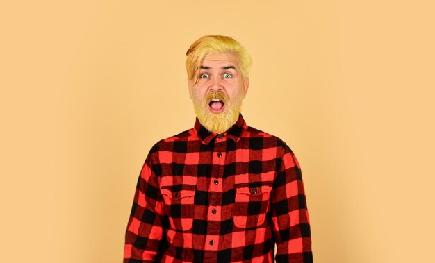 What a surprise mature hipster dyed beard hairdresser and barbershop brutal male blonde hair portrait surprised man casual fashion barber master with moustache bearded man checkered shirt