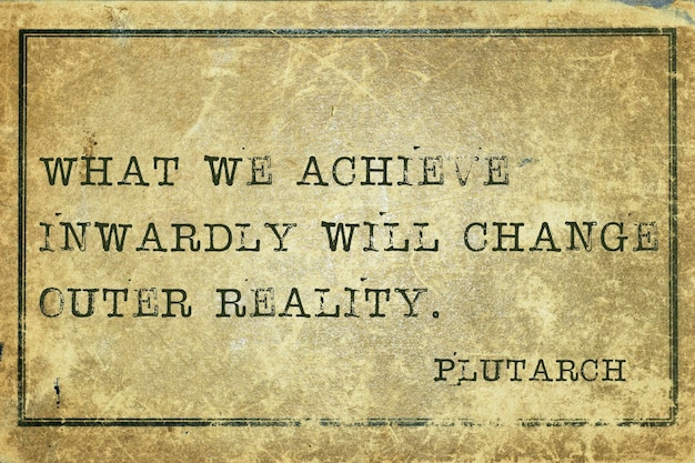 What we achieve inwardly - ancient Greek philosopher Plutarch quote printed on grunge vintage cardboard