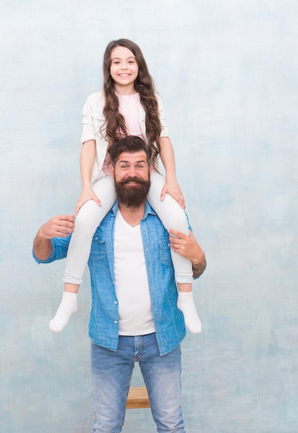 Do what you like Baby girl enjoy active game with father Bearded man piggyback small child Casual look of happy family Casual wear Fashion trends Trendy style Hair salon Barbershop