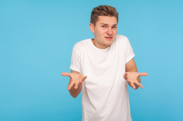What do you want portrait of confused man in tshirt expressing\
misunderstanding gesturing in puzzlement with indignant face asking\
why39d you do that indoor studio shot isolated on blue\
background