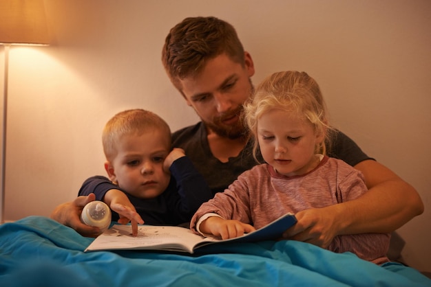 Whats that Daddy A father reading a bedtime story to his kids