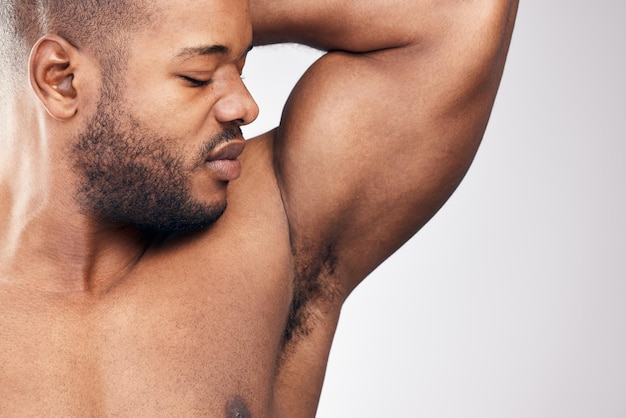 Whats that smelly smell Studio shot of a handsome young man smelling his armpit against a white background