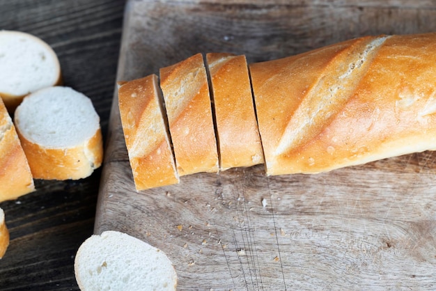 Wheat baguette cut into pieces on a cutting board