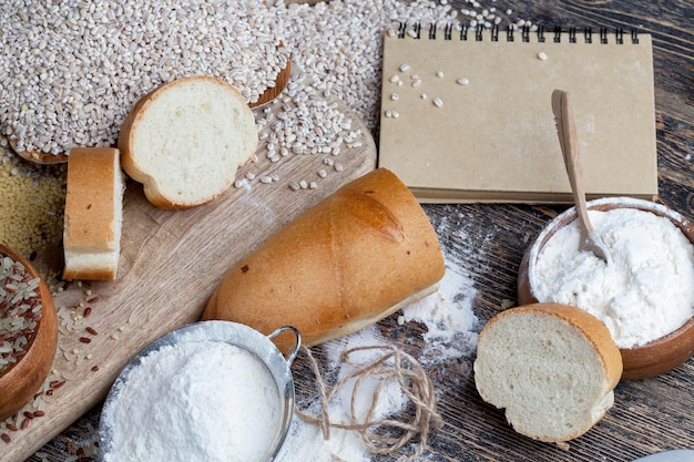 Wheat baguette on the table with flour and various plant grains