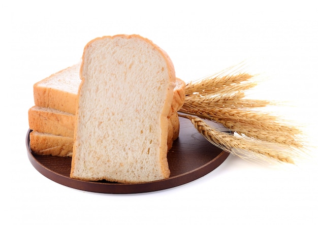 Wheat bread and grains and ears on white background