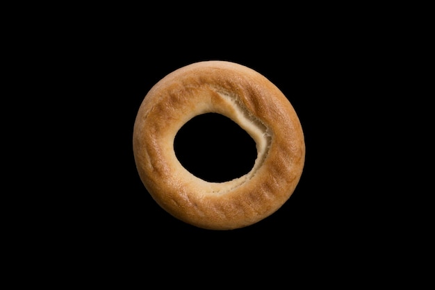 Wheat choux pastry loaf in the form of a ring. bagel isolated on black background. High quality photo