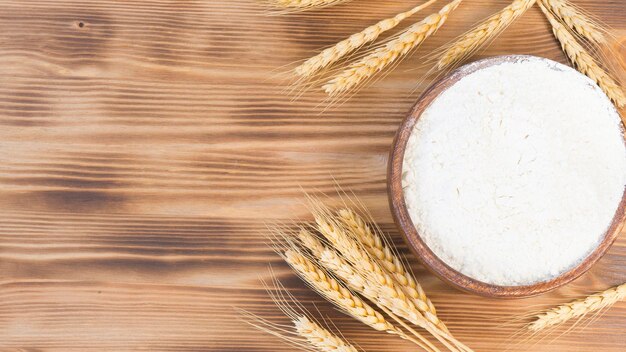 Wheat ears and wooden bowl with wheat flour