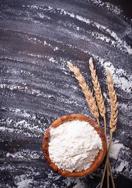 Wheat flour in bowl and ears