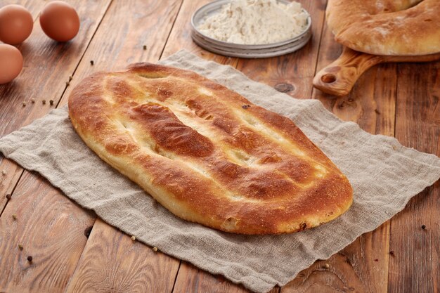 Wheat flour bread, wooden background