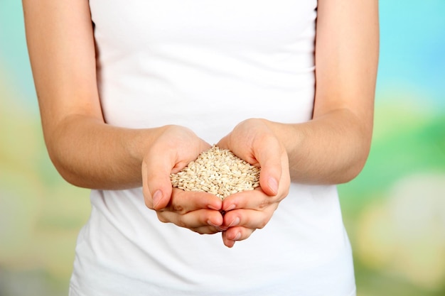 Foto grano di grano in mani femminili su sfondo naturale