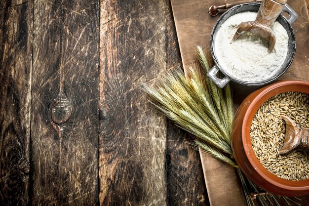 Wheat grains in a bowl. On a wooden background.