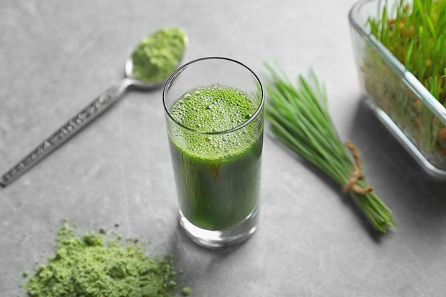 Wheat grass shot on grey surface