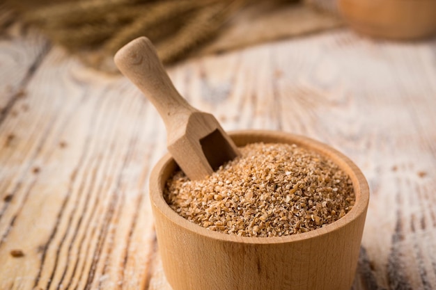 Wheat groats in a bowl on a wooden background Healthy dietary cereals concept