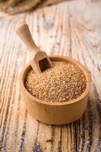 Wheat groats in a bowl on a wooden background Healthy dietary cereals concept