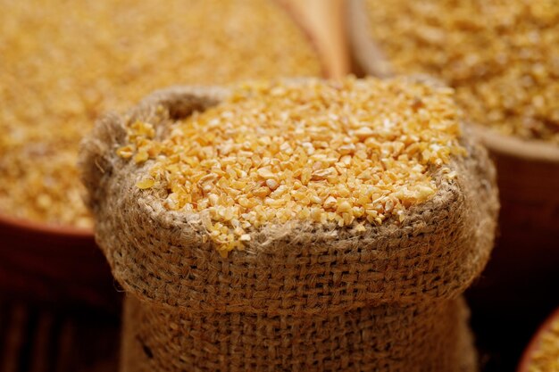 Wheat groats in bowls and bags on a wooden background High quality photo