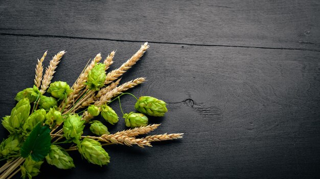 Wheat and hops on a wooden background Top view Free space for text